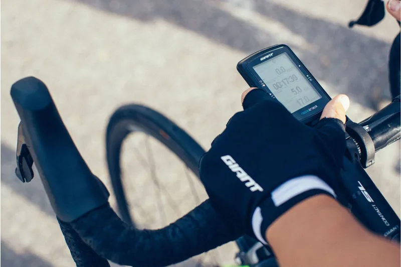 Overhead shot of a gloved hand on a Giant drop-bar holding a Giant cycling computer reading 00:17:30 elapsed. A bike that was sold, serviced and ridden out the door.